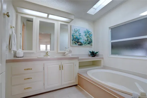 a bathroom with a granite countertop sink and a bathtub