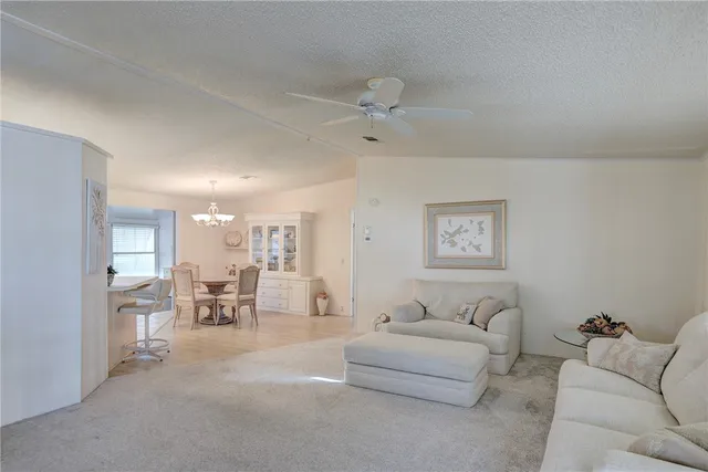 a living room with furniture and a dining table with projector