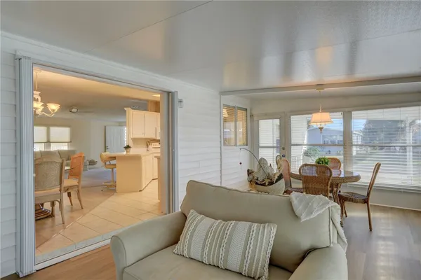 a living room with furniture and a dining table with wooden floor