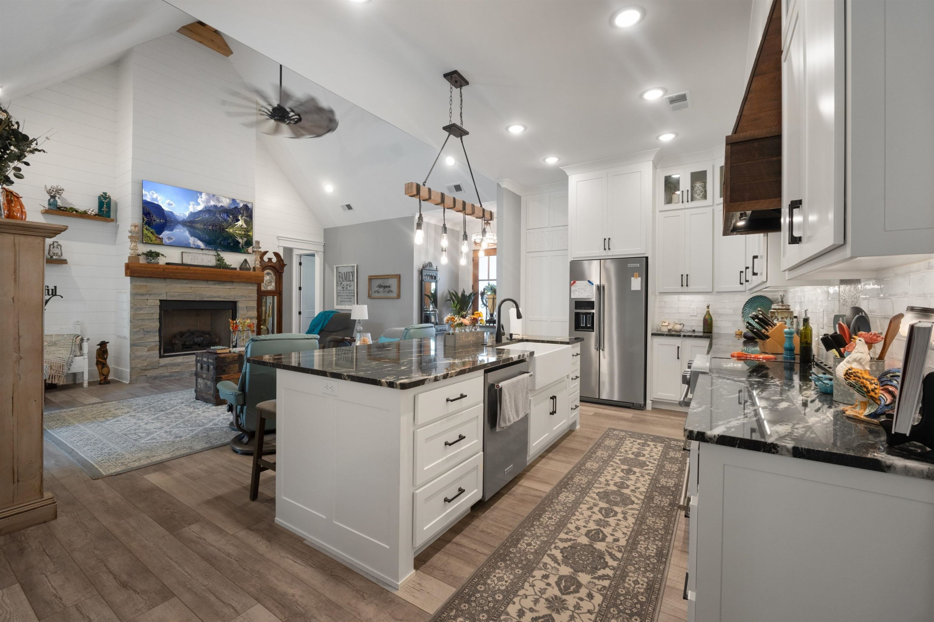 491 Cooper Anderson Road Jackson, TN 38305 - Photo 9 of 30 a kitchen with stainless steel appliances kitchen island granite countertop a refrigerator oven a sink dishwasher and a fireplace with wooden floor