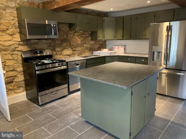 a kitchen with stainless steel appliances granite countertop a stove a refrigerator and a sink