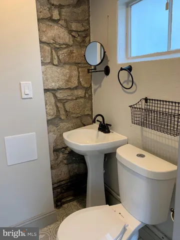 a bathroom with a toilet a sink and mirror