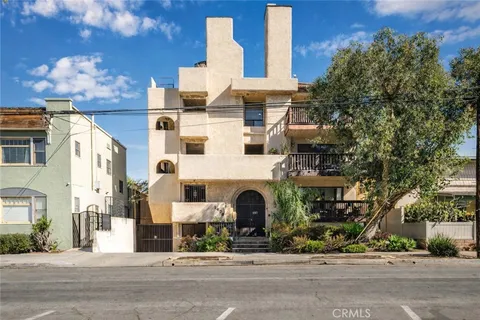 a view of a cars park in front of a building