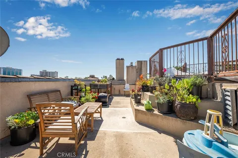 a view of a balcony with chairs and potted plants