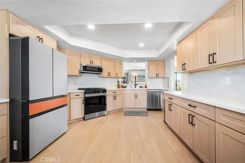 a kitchen with white cabinets and stainless steel appliances