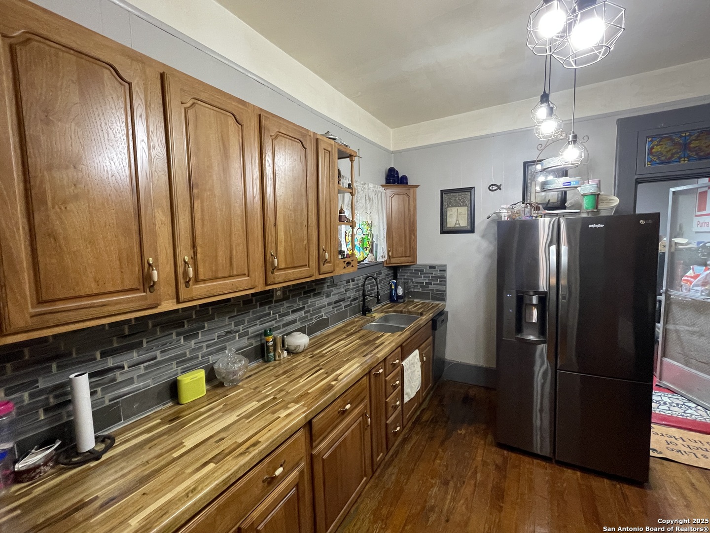 601 Berlin Street Castroville, TX 78009 - Photo 6 of 17 a kitchen with stainless steel appliances granite countertop a refrigerator a stove and a wooden floors