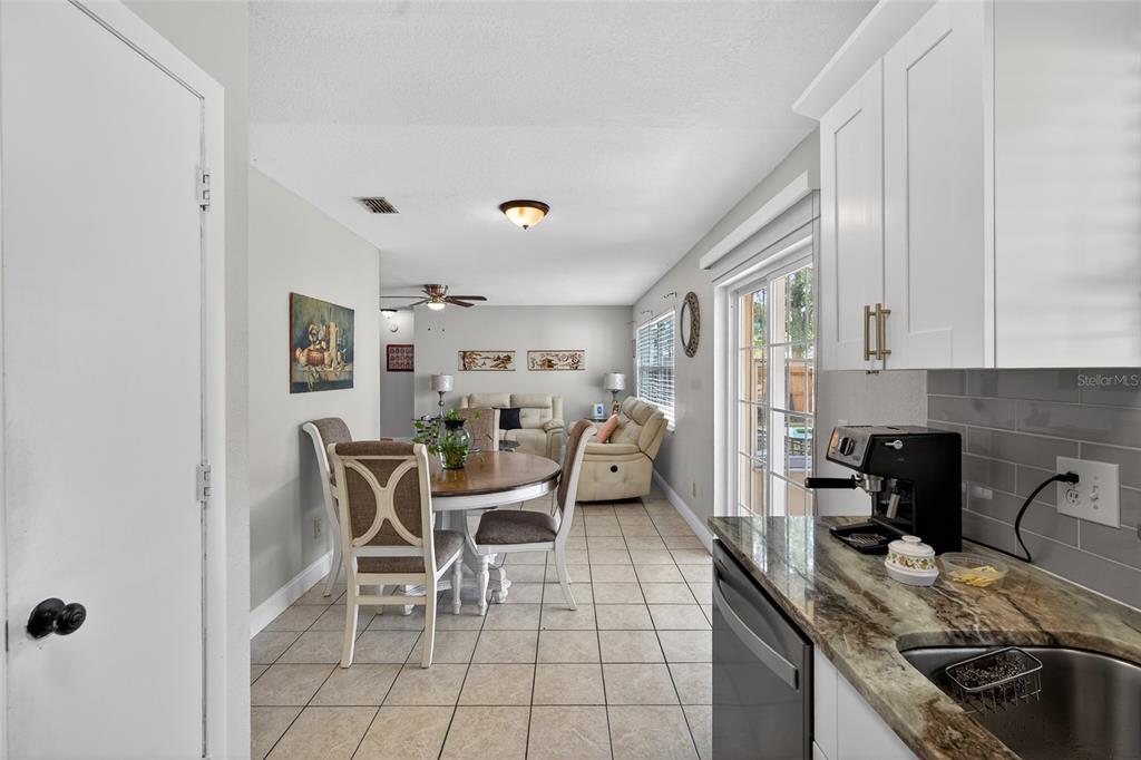 5438 Snowflake Court Orlando, FL 32839 - Photo 26 of 38 a kitchen with granite countertop lots of white cabinets stainless steel appliances a sink and a counter top space
