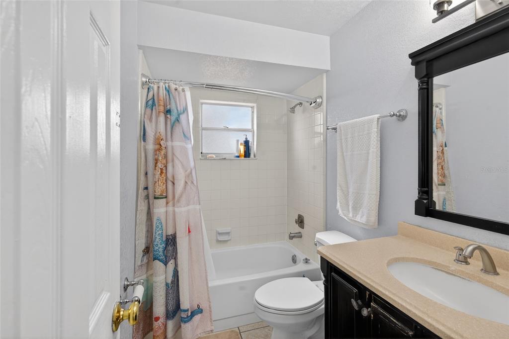 5438 Snowflake Court Orlando, FL 32839 - Photo 31 of 38 a bathroom with a granite countertop sink toilet and shower