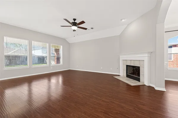 a view of empty room with wooden floor and fireplace