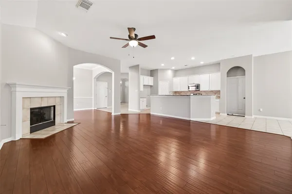 a view of a kitchen with a sink a fireplace a window and wooden floor