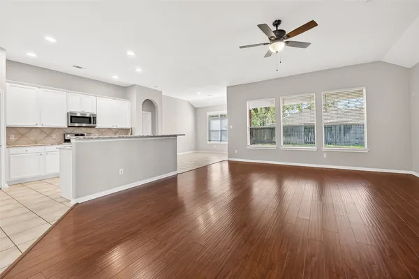 a view of a kitchen with wooden floor and a window