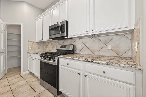 a kitchen with stainless steel appliances granite countertop a stove a microwave and a sink