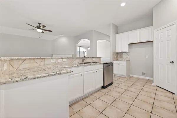 a kitchen with granite countertop white cabinets and white appliances