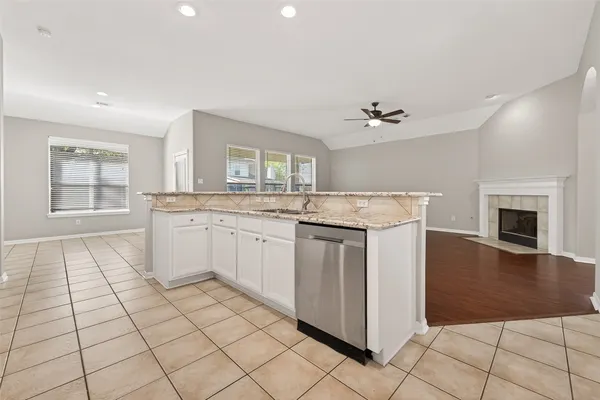 a kitchen with a sink a stove cabinets and a window
