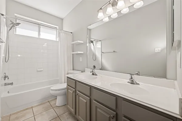 a bathroom with a tub a sink and mirror