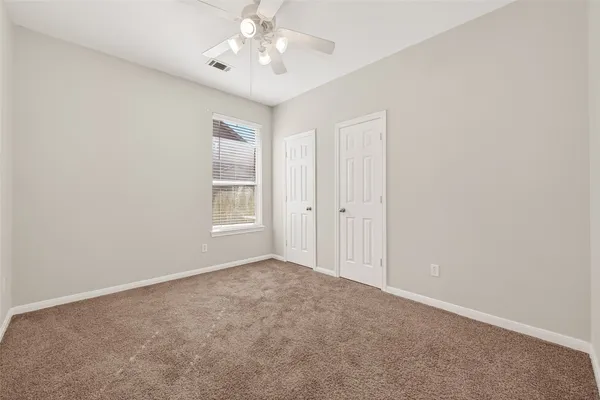an empty room with a chandelier fan