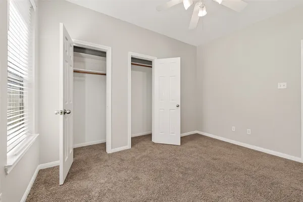 an empty room with windows and closet