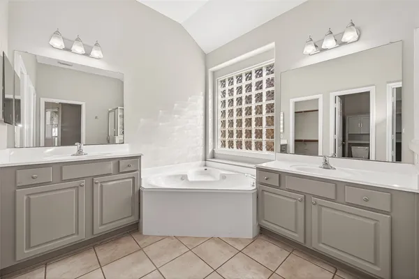 a bathroom with a sink mirror and a bathtub