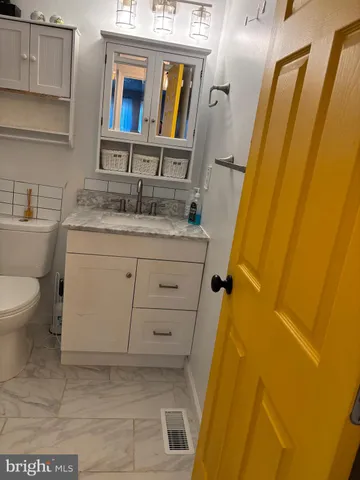 a bathroom with a granite countertop sink and a mirror