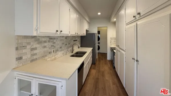a kitchen with a sink a refrigerator and cabinets