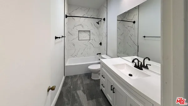 an empty room with wooden floor and hallway