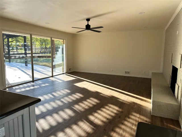 a view of a livingroom with wooden floor and a ceiling fan