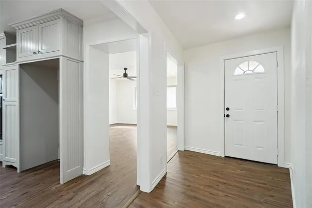 an empty room with wooden floor and closet area