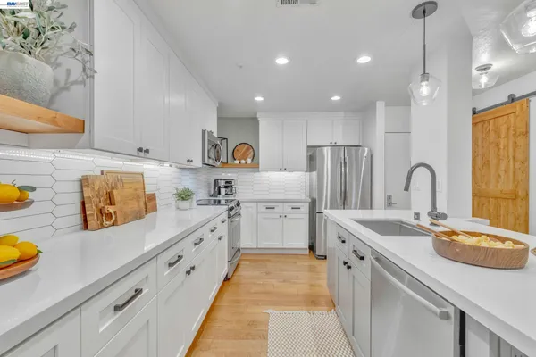 a kitchen with stainless steel appliances granite countertop a sink a stove and a refrigerator