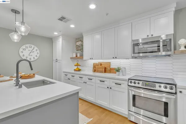 a kitchen with stainless steel appliances a stove refrigerator sink and cabinets