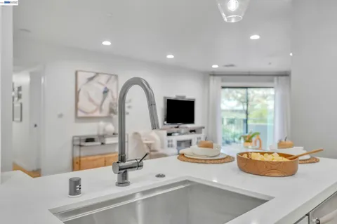 a kitchen with a sink and a stove top oven with wooden floor