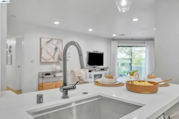 a kitchen with a sink and a stove top oven with wooden floor