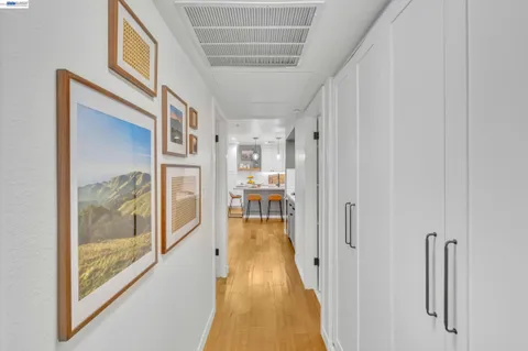 a view of a hallway with wooden floor and windows