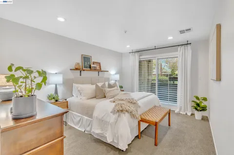 a bedroom with a bed and a lamp on dresser