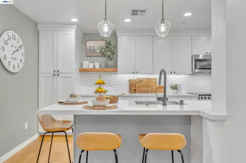 a kitchen with a dining table chairs and a refrigerator