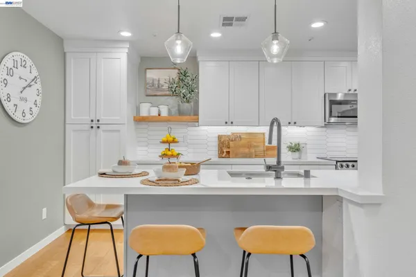 a kitchen with a dining table chairs and a refrigerator