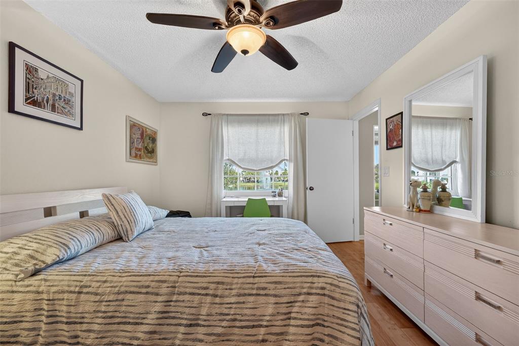 1438 Millstream Lane, Unit 105 Dunedin, FL 34698 - Photo 21 of 34 a bedroom with a large bed and a chandelier