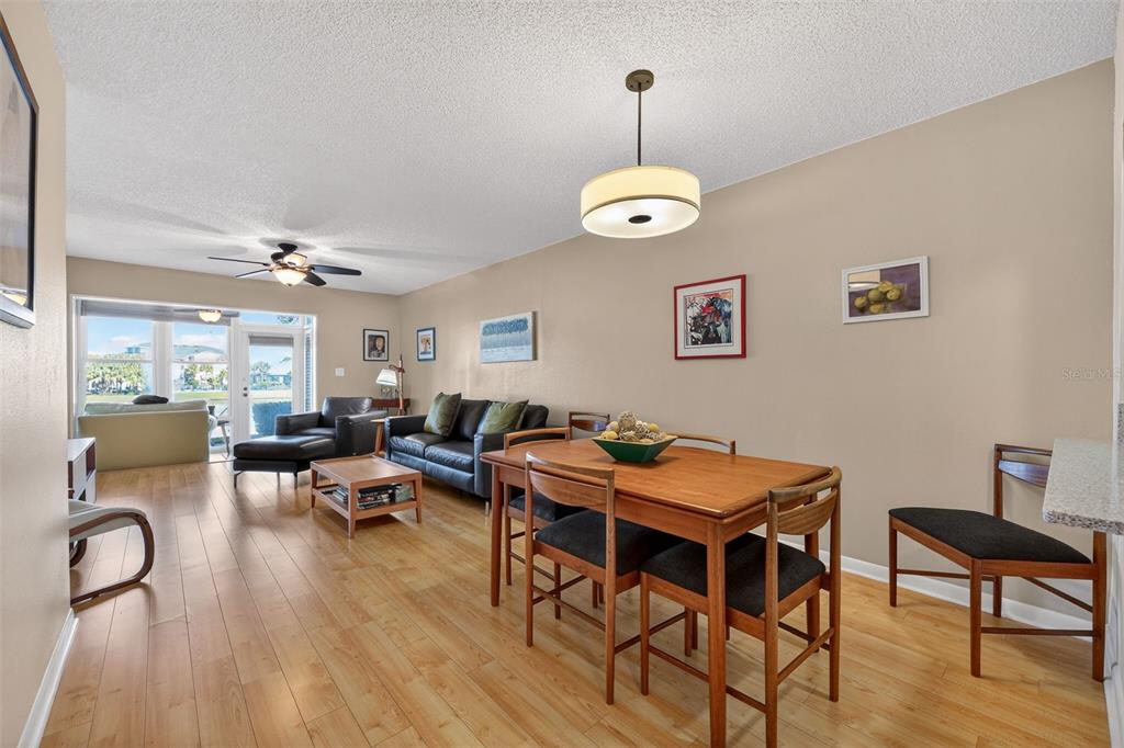 1438 Millstream Lane, Unit 105 Dunedin, FL 34698 - Photo 9 of 34 a view of a dining room with furniture wooden floor and chandelier