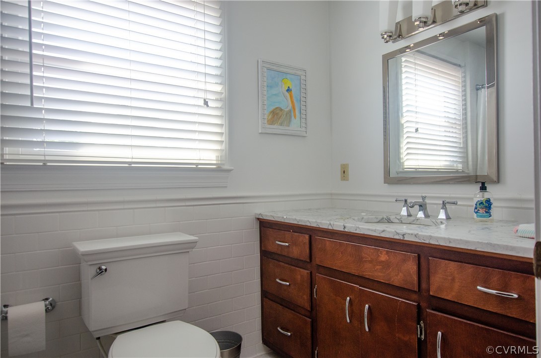 4773 Windmill Point Road White Stone, VA 22578 - Photo 26 of 36 a bathroom with a granite countertop toilet sink and mirror