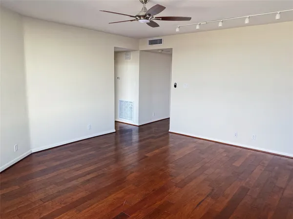 a view of an empty room with wooden floor