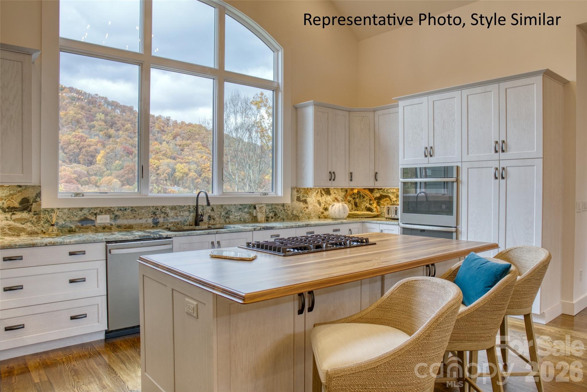 301 Awohali Trail Maggie Valley, NC 28751 - Photo 7 of 31 a kitchen with a stove a sink and white cabinets with wooden floor