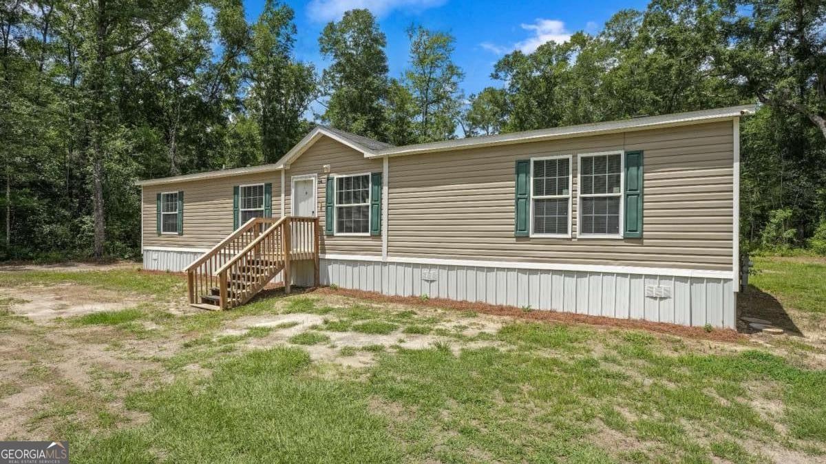 64 Sierra Road Jesup, GA 31545 - Photo 3 of 22 a view of a house with a yard and large tree