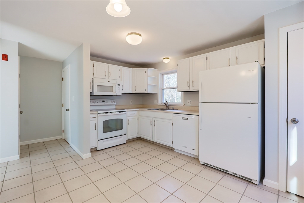 131 Harkness Road, Unit B Millville, MA 01529 - Photo 17 of 41 a white kitchen with cabinets stainless steel appliances and a sink