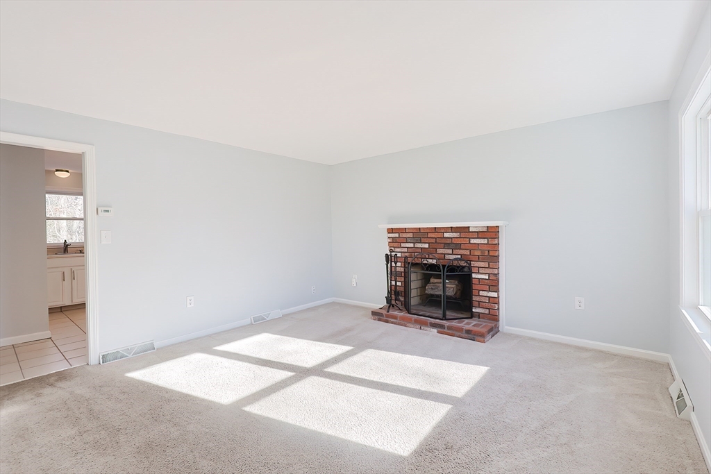 131 Harkness Road, Unit B Millville, MA 01529 - Photo 28 of 41 an empty room with floor to ceiling window and fireplace