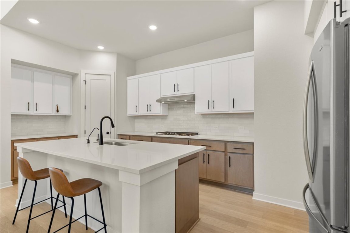 1020 Highcrest Georgetown, TX 78628 - Photo 11 of 39 a kitchen with stainless steel appliances granite countertop a stove a sink a refrigerator and white cabinets with wooden floor