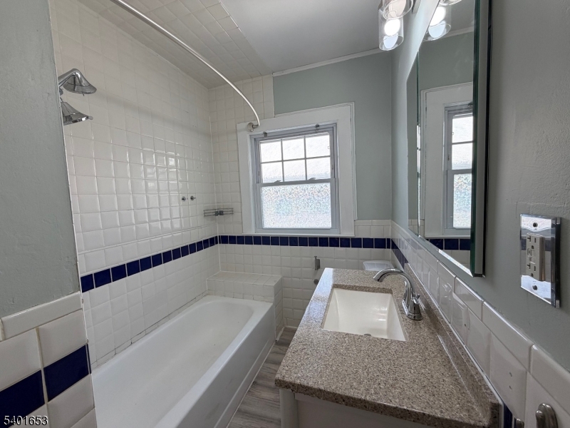 63 Watchung Avenue, Unit 2 Montclair, NJ 07043 - Photo 11 of 21 a bathroom with a granite countertop tub sink and mirror