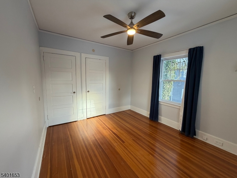 63 Watchung Avenue, Unit 2 Montclair, NJ 07043 - Photo 15 of 21 an empty room with wooden floor chandelier fan and windows