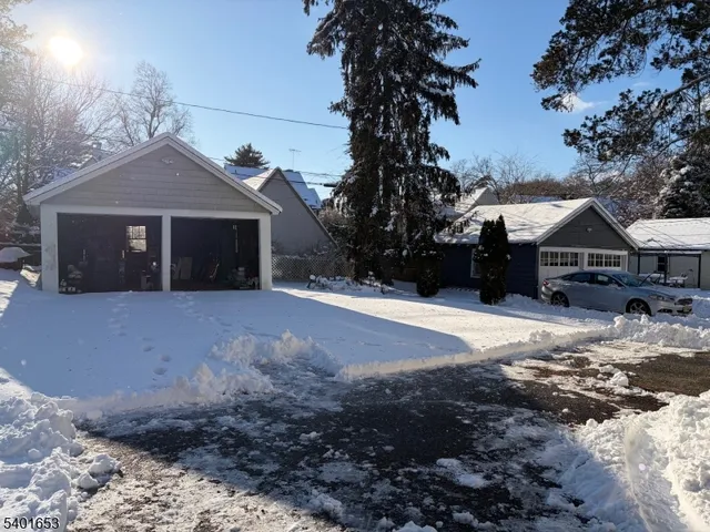 a front view of a house with a yard covered with snow