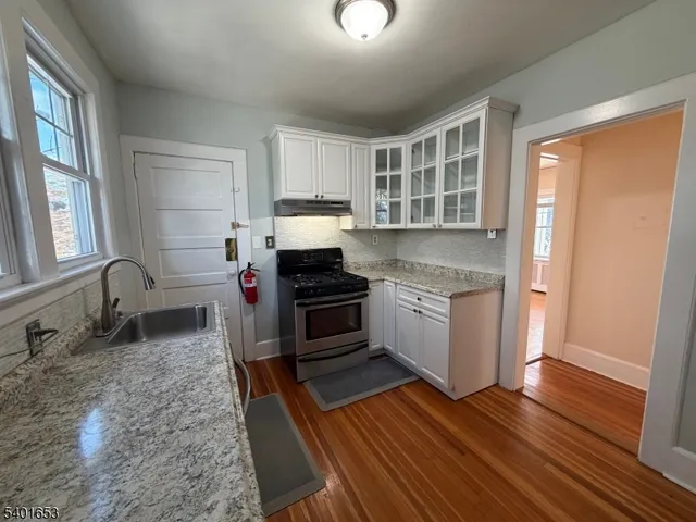 a kitchen with granite countertop a stove and a sink