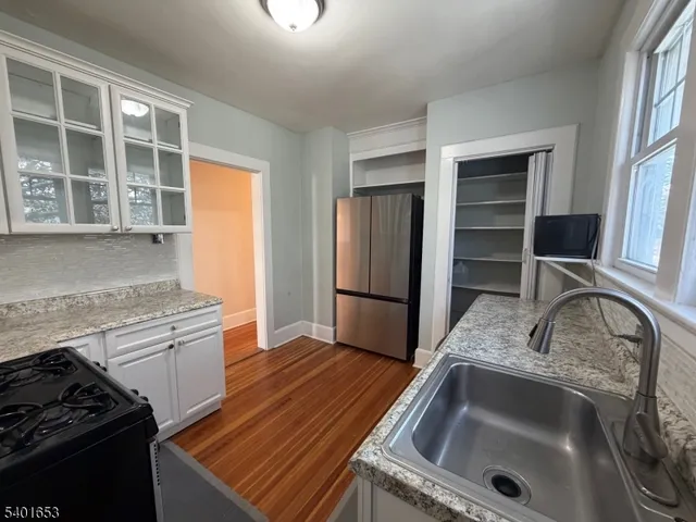 a kitchen that has a sink wooden floor and a stove