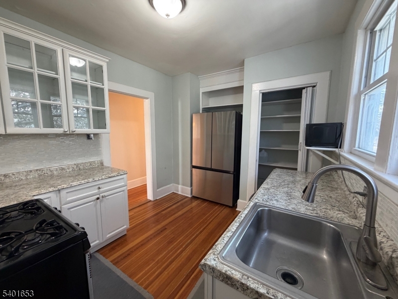 63 Watchung Avenue, Unit 2 Montclair, NJ 07043 - Photo 10 of 21 a kitchen that has a sink wooden floor and a stove